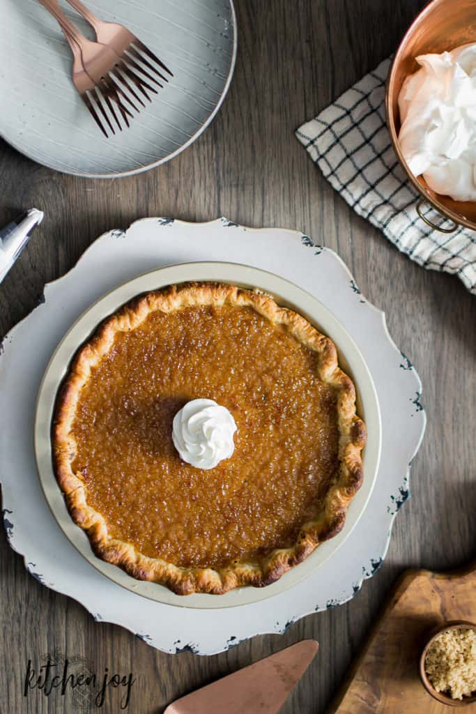 whole maple bourbon pumpkin pie with crispy brulee top and a dollop of whipped cream