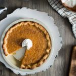 whole pie with slice removed, maple bourbon pumpkin pie with brulee crust topped with whipped cream