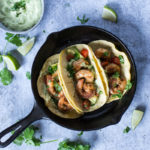 shrimp tacos with corn tortillas in a skillet