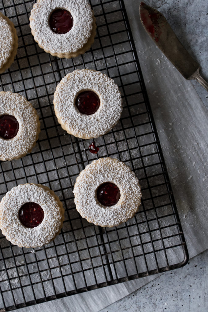 jam-filled linzer cookies arranged on a cooling rack