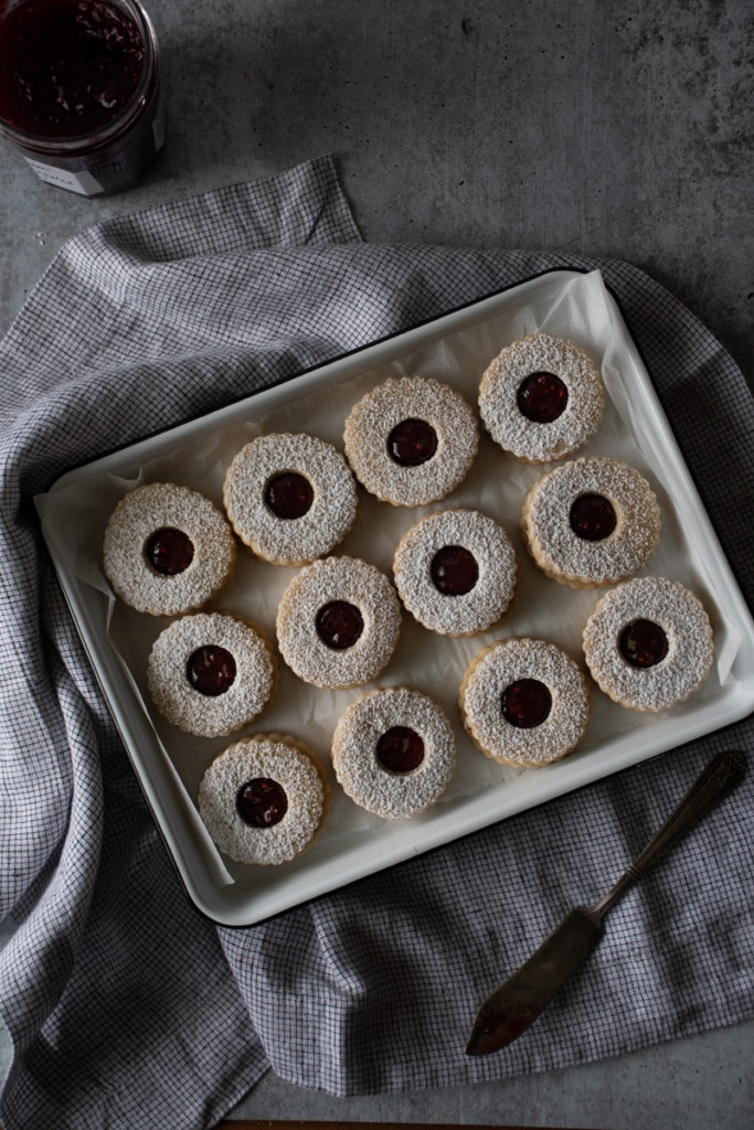 tray of jam-filled linzer cookies dusted with powdered sugar