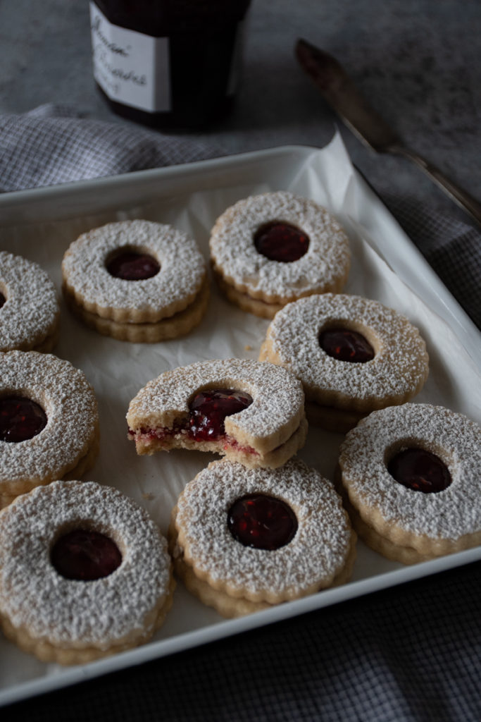 tray of linzer cookies, one with a bite out