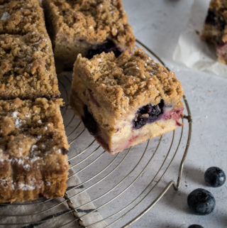 mixed berry crumb cake coffee cake cut into squares on a cooling rack