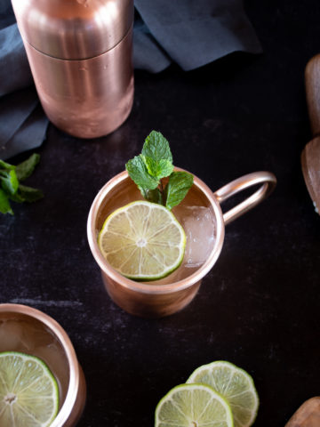 ginger gin mule cocktail served in frosty copper mug topped with lime wedge and sprigs of mint