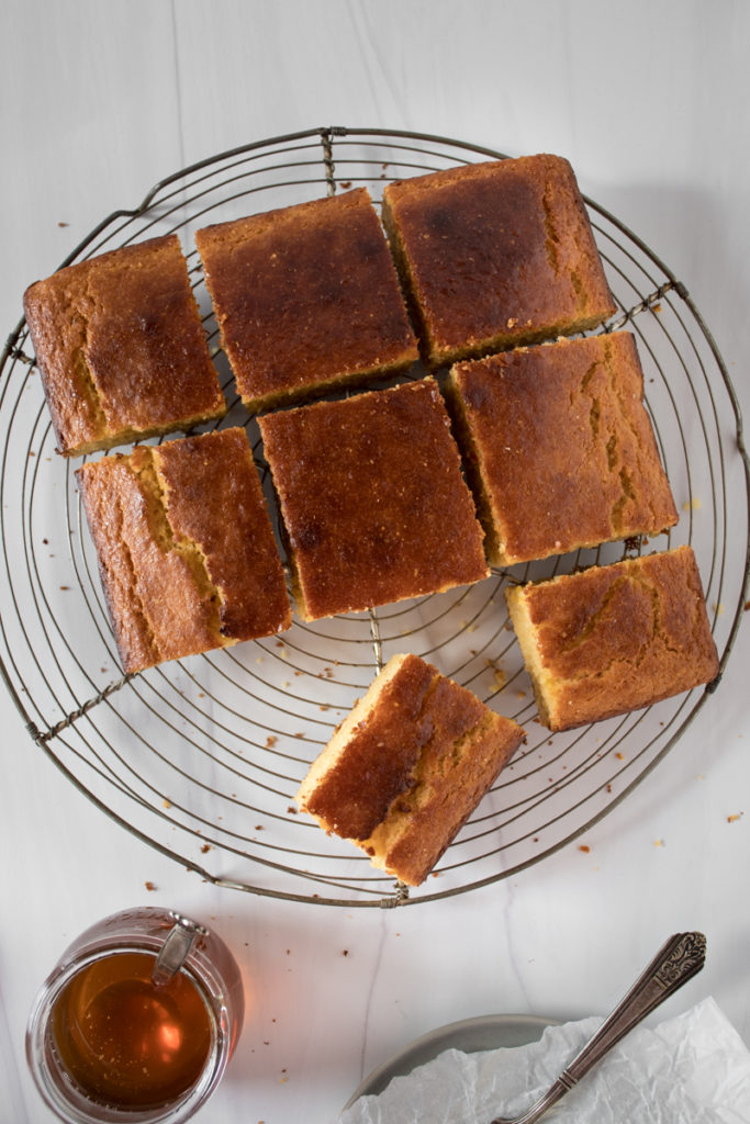 sweet honey cornbread cooling on a wire rack, cut into squares, served with honey
