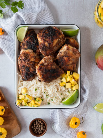 jamaican jerk chicken thighs smoked in an oven served with rice and mango salsa