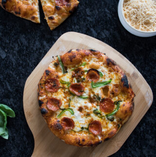 freshly baked homemade pizza with sourdough crust, sitting on a wooden pizza peel